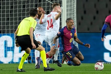 El centrocampista del Sevilla 'Peque' Fernández (2-d) comete penalti sobre Raphinha (d), durante el partido de LaLiga que FC Barcelona y Sevilla FC disputan este domingo en el estadio Lluis Companys.
