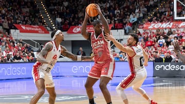 MURCIA, 18/01/2026.- El ala pívot estadounidense de UCAM Murcia Kelan Dewayne Martin (c) controla el balón ante el ala pívot estadounidense de Zaragoza Casademont Devin Robinson (i) y Marco Spissu (d), durante el partido de la décimo sexta jornada de la Liga Endesa que están disputando UCAM Murcia contra Zaragoza Casademont, este domingo en el Palacio de los Deportes de Murcia.- EFE/ Marcial Guillén