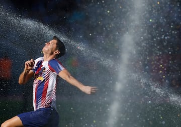Robert Lewandowski corre a trav¨¦s de los aspersores del Estadio Ol¨ªmpico Llu¨ªs Companys durante el calentamiento.