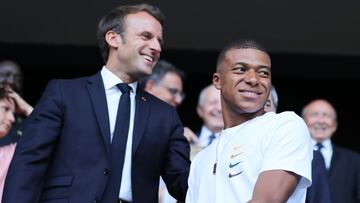 Emmanuel Macron habla con Mbapp&eacute; durante un acto p&uacute;blico.