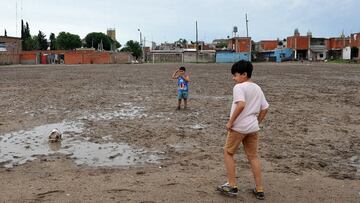Dos niños juegan con un deteriorado balón en la vetusta y embarrada cancha del Club Atlético Estrella Roja, en Villa Fiorito, en la provincia de Buenos Aires. Esa misma cancha que años atrás tantas veces vio jugar, entre