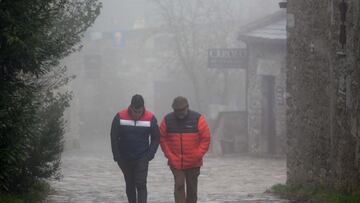 Dos hombres caminan entre la niebla en la aldea prerromana de O Cebreiro, Concello de Pedrafita do Cebreiro, Lugo, Galicia (Espa&ntilde;a). A Monta&ntilde;a lucense ha registrado las primeras nevadas en las  zonas m&aacute;s altas de Cervantes y Pedrafita