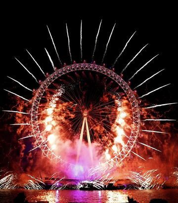 Fireworks explode over the London Eye during the New Year's eve celebrations after midnight in London, Tuesday, Jan. 1, 2019.(AP Photo/Kirsty Wigglesworth) *** Local Caption *** .