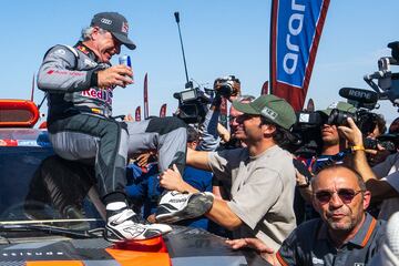 El piloto español del equipo Audi Sport Carlos Sainz, es felicitado por su hijo, el piloto de Fórmula 1 Carlos Sainz Jr., tras cruzar la línea de meta y conseguir la victoria del Dakar 2024.