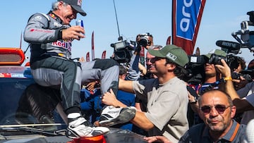 El piloto español del equipo Audi Sport Carlos Sainz, es felicitado por su hijo, el piloto de Fórmula 1 Carlos Sainz Jr., tras cruzar la línea de meta y conseguir la victoria del Dakar 2024.