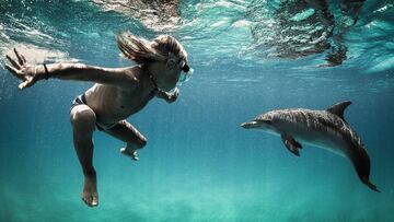 Joshua Karbus nadando junto a su inseparable amigo delf&iacute;n