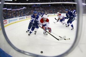 Steven Stamkos de Tampa Bay Lightning y David Desharnais de Montreal Canadiens luchan por el control del disco en el partido de la NHL.