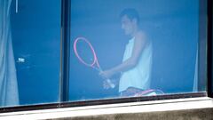 Australian tennis player Bernard Tomic exercises in his hotel room in Melbourne in January 17, 2021, as players quarantine in hotels ahead of the Australian Open tennis tournament. (Photo by William WEST / AFP)