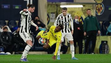 Villarreal's Nigerian midfielder Samuel Chukwueze (C) falls as he fights for the ball with Juventus' French midfielder Adrien Rabiot (L) during the UEFA Champions League football match between Villarreal and Juventus at La Ceramica stadium in Vi