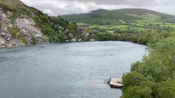 El famoso lago para el buceo de Portroe Quarry, Tippery (Irlanda), con campos al fondo y nubes oscuras en el cielo.