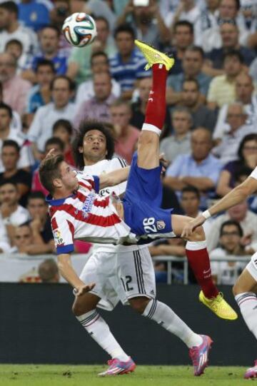 El centrocampista del Atlético de Madrid Saúl Ñiguez remata de chilena ante el defensa brasileño del Real Madrid Marcelo.