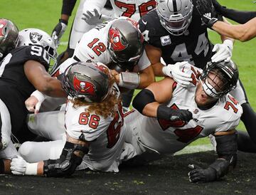 El quarterback Tom Brady, ahora en los Tampa Bay Buccaneers, batió el domingo el récord total de pases de touchdown que ostentaba hasta ahora Drew Brees. Brady lanzó para cuatro touchdowns y consiguió otro más de carrera, momento que capta la imagen, en el partido que enfrentó a su equipo contra Las Vegas Raiders.