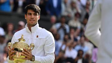 Spain's Carlos Alcaraz poses with the winner's trophy after beating Serbia's Novak Djokovic during their men's singles final tennis match on the fourteenth day of the 2024 Wimbledon Championships at The All England Lawn Tennis and Croquet Club in Wimbledon, southwest London, on July 14, 2024. Defending champion Alcaraz beat seven-time winner Novak Djokovic in a blockbuster final, with Alcaraz winning 6-2, 6-2, 7-6. (Photo by ANDREJ ISAKOVIC / AFP) / RESTRICTED TO EDITORIAL USE