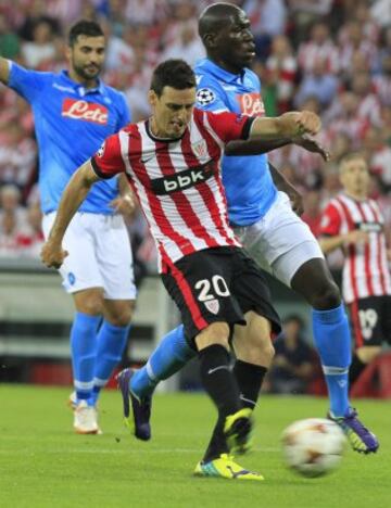 El delantero del Athletic Club Aritz Aduriz (i) dispara ante la oposición del defensa francés Kalidou Koulibaly (d), del Nápoles, durante el partido de vuelta de la fase previa de la Liga de Campeones que se disputa esta tarde en el estadio de San Mamés, en Bilbao. 