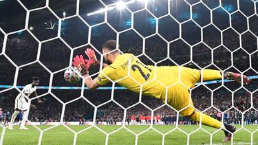 Italy's goalkeeper Gianluigi Donnarumma saves a shot by England's midfielder Bukayo Saka in the penalty shootout during the UEFA EURO 2020 final football match between Italy and England at the Wembley Stadium in London on July 11, 2021. (Photo b