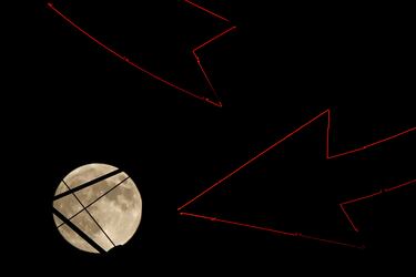 La luna se eleva tras un cartel antiguo en la cima de un edificio de apartamentos en el centro de la ciudad, el miércoles 16 de octubre de 2024, en Kansas City.