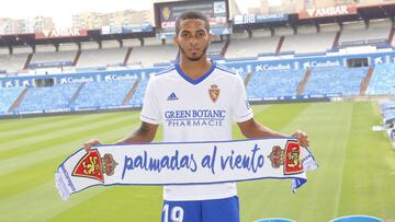 César Yanis posa con una bufanda del Real Zaragoza en su presentación en La Romareda.