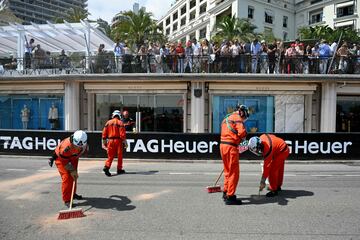 Los comisarios de carrera limpian la pista después del accidente de Checo Pérez.