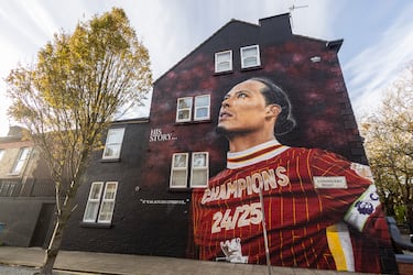 Uno de los murales más recientes. El penúltimo en añadirse a este particular paseo de la fama del Liverpool. Van Dijk, con la camiseta conmemorativa del campeonato de la Premier y el brazalete de capitán. “Su historia… ‘Siempre fue el Liverpool”.