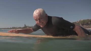 El shapter y surfista Bob McTavish remando con su tabla de surf a los 76 años.