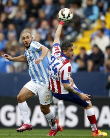 El delantero neerlandés-marroquí del Málaga Nordin Amrabat, lucha el balón ante el defensa uruguayo del Atlético de Madrid José María Giménez, durante el partido de la trigésimo primera jornada de Liga