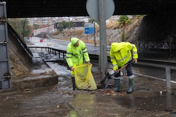 Mantenimiento de la calzada anegada en el paso subterráneo en la barriada de Palmete de Sevilla.