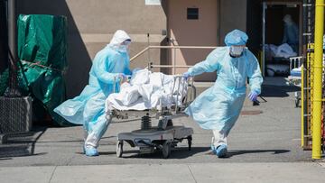 (FILES) In this file photo taken on April 6, 2020, bodies are moved to a refrigeration truck serving as a temporary morgue at Wyckoff Hospital in the Borough of Brooklyn in New York. (Photo by Bryan R. Smith / AFP)