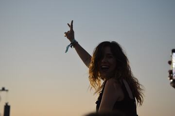 Mujer a hombros esperando ver Metallica al atardecer.