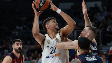 El pívot caboverdiano del Real Madrid Walter Tavares se dispone a lanzar ante Matt Costello, pívot estadounidense del Baskonia.