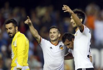 Los jugadores del Valencia Piatti y Cancelo felicitan a Alcácer (2-d) tras marcar el primer gol en presencia de Juan Carlos, portero del Córdoba, durante el partido de la quinta jornada de Liga en Primera División que disputan esta noche en el estadio de Mestalla, en Valencia. 