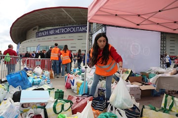 Voluntarios del Atlético de Madrid colocan los productos donados por los aficionados del club rojiblanco. 