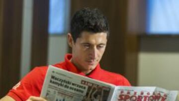 Lewandowski, posando para el periódico Przeglad Sportowy al llegar a Varsovia la semana pasada, con la portada que vincula su futuro al Madrid.