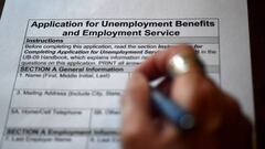 (FILES) In this file photo illustration taken on April 16, 2020, a person files an application for unemployment benefits, in Arlington, Virginia. - Another 3.84 million US workers filed for unemployment benefits last week and the total has now passed 30 m