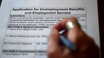 (FILES) In this file photo illustration taken on April 16, 2020, a person files an application for unemployment benefits, in Arlington, Virginia. - Another 3.84 million US workers filed for unemployment benefits last week and the total has now passed 30 m