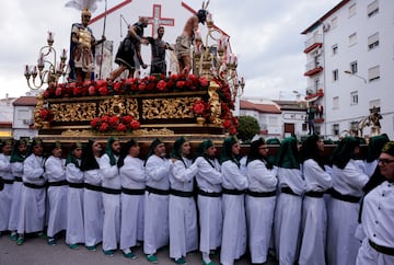 Miembros de la hermandad de La Columna llevan una estatua de Cristo sobre una estructura con peso, tradicionalmente conocida como 'trono', mientras participan en una procesión, durante la Semana Santa en Ronda.
