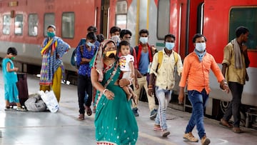 Migrant workers and their families, who had left during a lockdown, walk at a platform after they returned from their home state of Uttar Pradesh, after authorities eased lockdown restrictions that were imposed to slow the spread of the coronavirus diseas