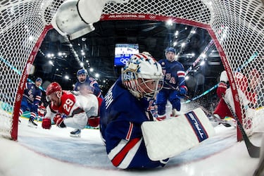 El estadounidense Jeremy Swayman (centro) observa el puck tras el gol anotado por el danés Nick Olesen (derecha) durante el partido de hockey sobre hielo de la ronda preliminar masculina del Grupo C entre Estados Unidos y Dinamarca.