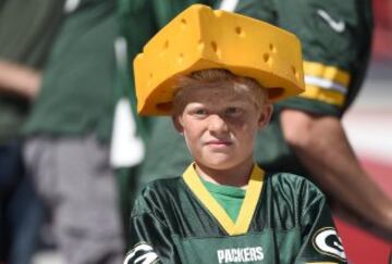Aficionado con un sombrero de queso en un partido de fútbol americano.