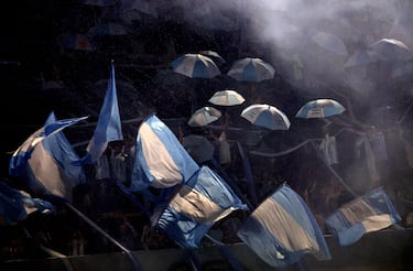 Aficionados argentinos con paraguas dentro del estadio antes del partido.