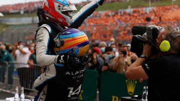 Alpine's French driver Esteban Ocon is carried by Alpine's Spanish driver Fernando Alonso after the Formula One Hungarian Grand Prix at the Hungaroring race track in Mogyorod near Budapest on August 1, 2021. (Photo by FLORION GOGA / AFP)