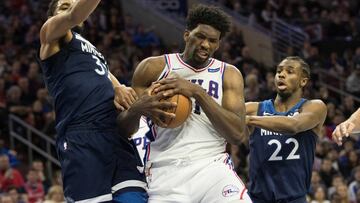 Joel Embiid, pívot de los Sixers, lucha por el balón con Karl-Anthony Towns y Andre Wiggins, de los Minnesota Timberwolves.