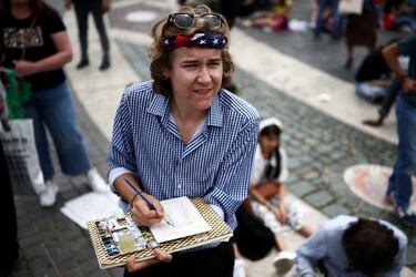 Una persona de Michigan, EE. UU., pinta una imagen de la Basílica de San Pedro mientras el Papa León XIV dirige la oración del Regina Caeli desde el balcón central (Loggia delle Benedizioni), en el Vaticano.