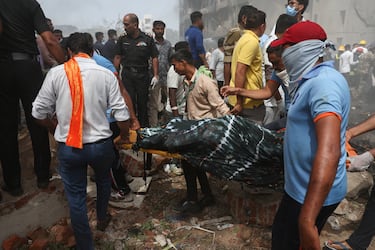 La gente lleva el cuerpo de una víctima del lugar del accidente después de que un avión Boeing 787 Dreamliner de Air India se estrellara en Ahmedabad, India.