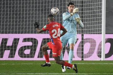 Granada's Brazilian midfielder Kenedy (L) vies with Real Madrid's Belgian goalkeeper Thibaut Courtois during the Spanish league football match between Real Madrid CF and Granada FC at the Alfredo di Stefano stadium in Valdebebas, on the outskirts of Madrid on December 23, 2020. (Photo by OSCAR DEL POZO / AFP)