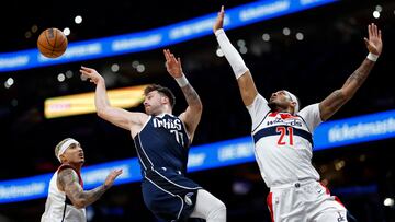 Dallas Mavericks guard Luka Doncic (77) leaps to pass the ball as Washington Wizards forward Kyle Kuzma (33) and Wizards center Daniel Gafford (21) defend in the first quarter at Capital One Arena.