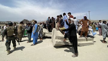 Kabul (Afghanistan), 17/08/2021.- Afghan security forces stand guard as people gather outside the Hamid Karzai International Airport to flee the country, after Taliban took control of Kabul, Afghanistan, 17 August 2021. Several people were reportedly kill
