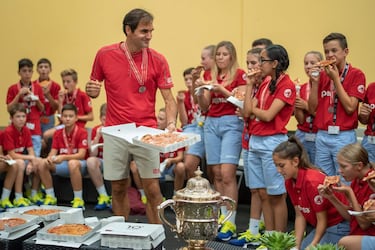 Roger Federer, nacido en Basilea hace 38 años, empezó en el torneo de su ciudad como recogepelotas. El día 27 de octubre conquistó su título por décima vez, y se le escapó alguna lagrimilla de emoción. Después tocó cumplir con una tradición: imponer la medalla de reconocimiento a los chavales que ahora son voluntarios... e invitarles a pizza.