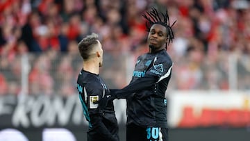 Bayer Leverkusen's Dutch defender #30 Jeremie Frimpong (R) celebrates scoring his team's first goal with Bayer Leverkusen's Spanish defender #20 Alejandro Grimaldo during the German first division Bundesliga football match between 1 FC Union Berlin and Bayer 04 Leverkusen in Berlin, on November 30, 2024. (Photo by Odd ANDERSEN / AFP) / DFL REGULATIONS PROHIBIT ANY USE OF PHOTOGRAPHS AS IMAGE SEQUENCES AND/OR QUASI-VIDEO