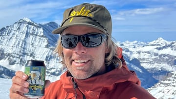 El snowboarder Ueli Kestenholz con una lata de cerveza en la mano en las montañas nevadas