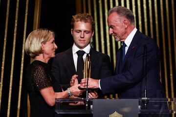 La viuda de Franz Beckenbauer, Heidi, el hijo de Franz Beckenbauer, Joel Beckenbauer, y el exjugador alemán Karl-Heinz Rummenigge suben al escenario durante un homenaje a Franz Beckenbauer durante la ceremonia de entrega del premio Balón de Oro.